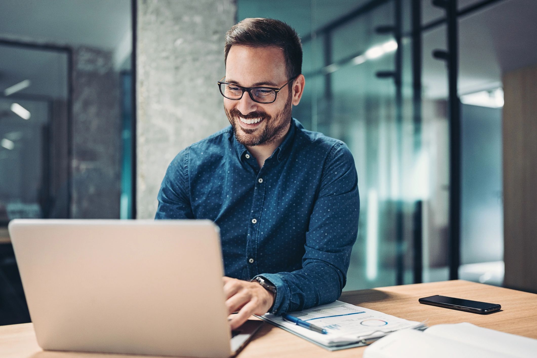 Automation consultant working on a laptop in a modern office